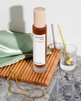 Henua toner glass bottle with a wooden cap on a bathroom setting