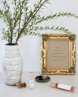 Henua skincare products on a table with crystal and sage on light background