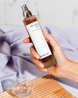 a hand holding a Henua toner bottle and lila background