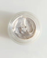 Henua microbiome mask with a close-up on the texture in a glass jar  on a white background