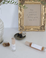 Henua skincare products on a table with crystal and sage